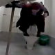 A hidden camera with no audio records a woman squatting over a toilet while taking a shit in a public restroom.
